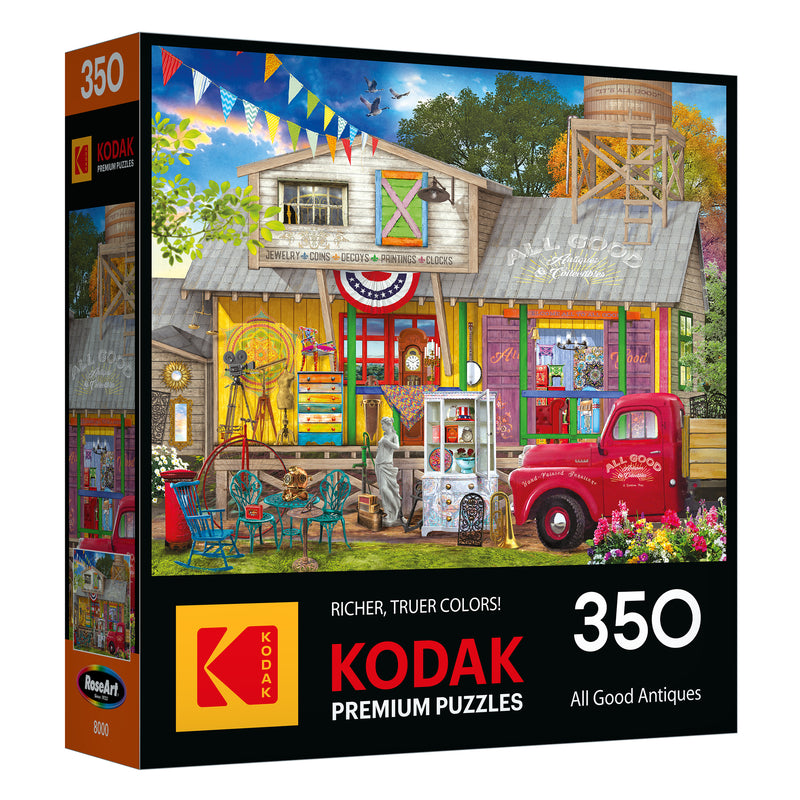 The ROSEART-KODAK PREMIUM All Good Antiques 350-piece jigsaw puzzle features a vibrant antique shop scene brimming with unique collectibles and a classic red truck out front.