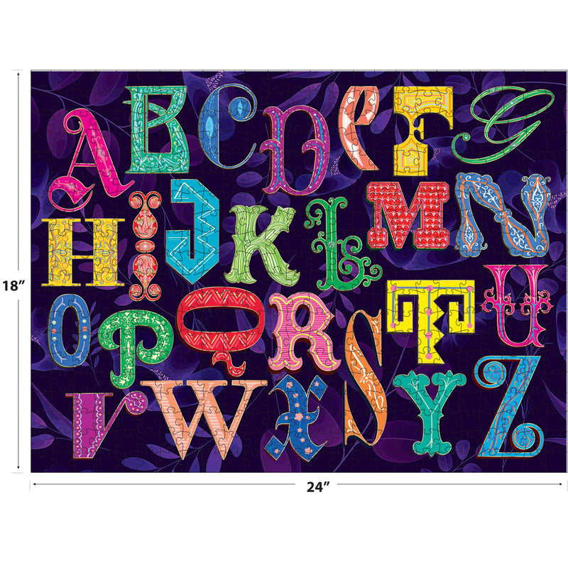 The ROSEART-ALPHABET PUZZLE is a 500-piece jigsaw featuring colorful, ornate alphabet letters arranged in three rows on a dark background with leaf patterns, measuring 18" x 24".