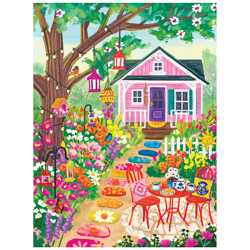 Enjoy assembling the ROSEART-OLIVIA GIBBS-FLORAL GARDEN 300 piece jigsaw puzzle, featuring a pink house, blooming flowers, lanterns, a tree, and a cozy tea patio along a stone path—a colorful and charming garden scene.