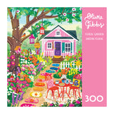 Colorful illustration of a vibrant floral garden with a pink house, tea table, and red chairs; blooming flowers featured on the ROSEART-OLIVIA GIBBS-FLORAL GARDEN-300 PIECE JIGSAW PUZZLE.