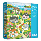 The ROSEART-OLIVIA GIBBS-COASTAL COTTAGE TOWN 300 piece jigsaw puzzle features colorful illustrated cottages, gardens, and scenic views—perfect for relaxing afternoons.