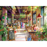 A vibrant cafe with customers dining and interacting, surrounded by lush greenery, colorful decor, and a chalkboard menu stand. The atmosphere is lively and inviting with natural light streaming in. RoseArt - My Happy Place - The Neighborhood Cafe - 750 Piece Jigsaw Puzzle.