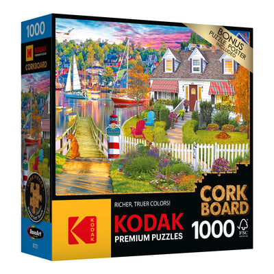 RoseArt - Kodak Cork - Charles Harbor - 1000 Piece Jigsaw Puzzle premium puzzle box showing a vibrant lakeside scene with boats, a house, and a garden. Includes 1000 pieces and a bonus puzzle poster.