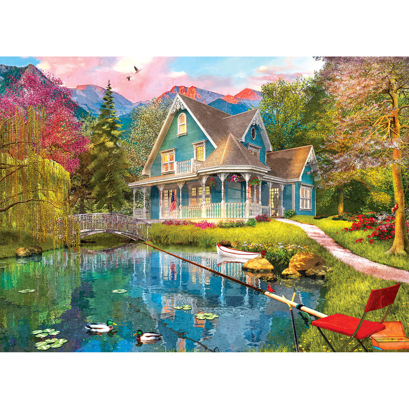 Colorful painting of a quaint house by a pond, surrounded by vibrant trees and flowers, with mountains in the background. Ducks are on the pond, a fishing rod is set up, and a chair is nearby. RoseArt - My Happy Place - Fishing Retreat - 1000 Piece Jigsaw Puzzle