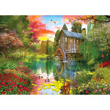 A serene pond with ducks and lily pads is surrounded by lush greenery and colorful flowers. An old wooden mill with a water wheel sits beside the pond under a vibrant, multicolored sky. This picturesque scene can be enjoyed in the RoseArt - My Happy Place - Sunset at the Mill - 1000 Piece Jigsaw Puzzle.