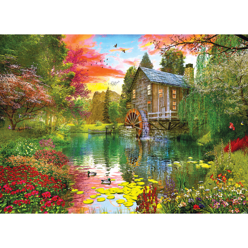 A serene pond with ducks and lily pads is surrounded by lush greenery and colorful flowers. An old wooden mill with a water wheel sits beside the pond under a vibrant, multicolored sky. This picturesque scene can be enjoyed in the RoseArt - My Happy Place - Sunset at the Mill - 1000 Piece Jigsaw Puzzle.