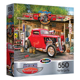 The ROSEART - AMERICAN NOSTALGIA - HOT ROD GAS UP 550-piece jigsaw puzzle showcases a red hot rod at a vintage gas station with retro signs and tools, capturing classic American nostalgia.