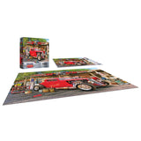 The completed ROSEART AMERICAN NOSTALGIA - HOT ROD GAS UP 550-piece jigsaw puzzle, showing a red vintage truck at an auto repair shop, is displayed alongside its box and cover art.