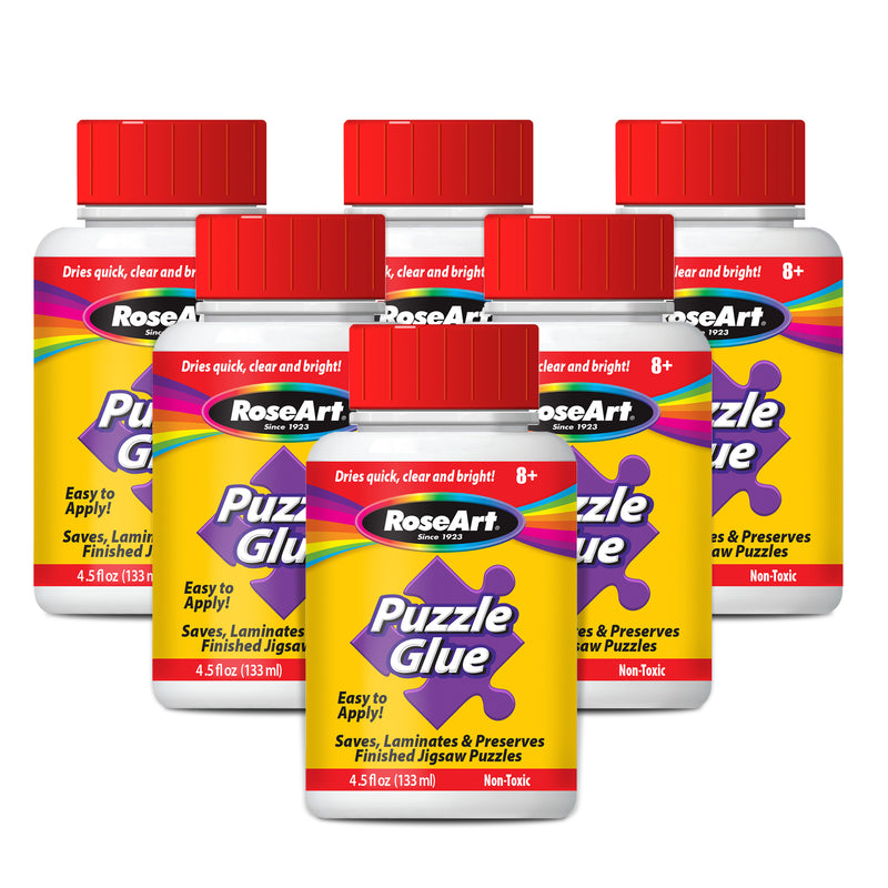 Image of six RoseArt - 4.5 oz Puzzle Glue 6 pack bottles. Each bottle has a red screw cap and a label displaying the brand name, product name, and usage details. The glue is described as non-toxic and suitable for ages 8 and up.