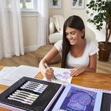 Girl drawing with the RoseArt Timeless Creations On Point Studio 45-piece dot art and coloring set with double-sided washable markers, coloring book, dot art posters and purple carrying case.