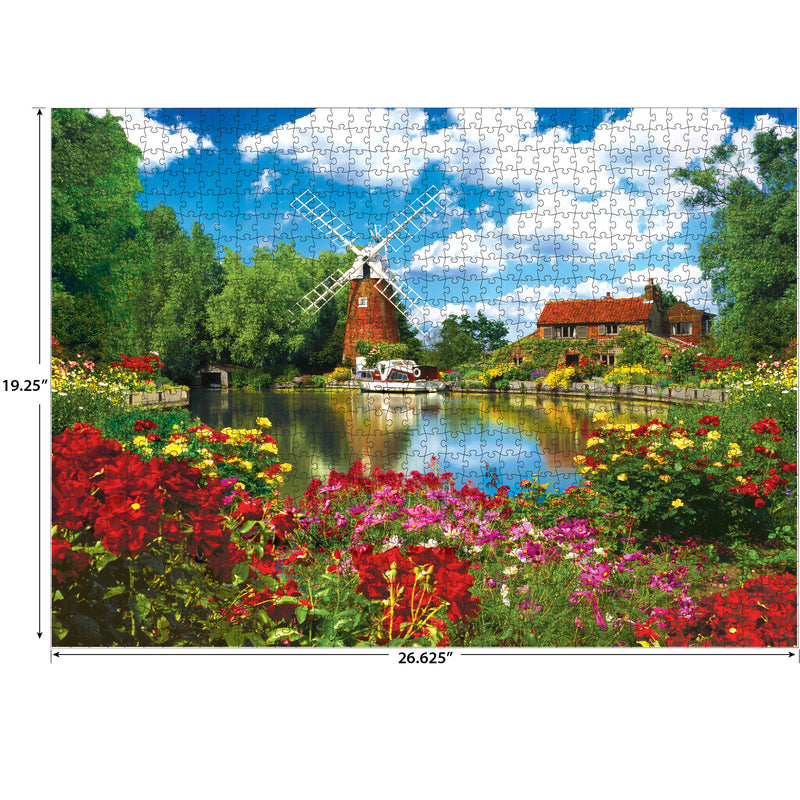A completed RoseArt - Kodak Premium - Hunsett Mill and the River Ant, Norfolk, England - 1000 Piece Jigsaw Puzzle depicting a serene countryside scene featuring a windmill, flowers, a pond, and houses. Puzzle dimensions are 19.25 inches by 26.625 inches.