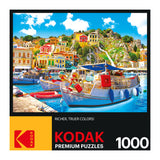 RoseArt - Kodak Premium - Symi with Boats in the Harbor, Greece - 1000 Piece Jigsaw Puzzle featuring a vibrant waterfront scene with colorful buildings, boats, and clear blue water.