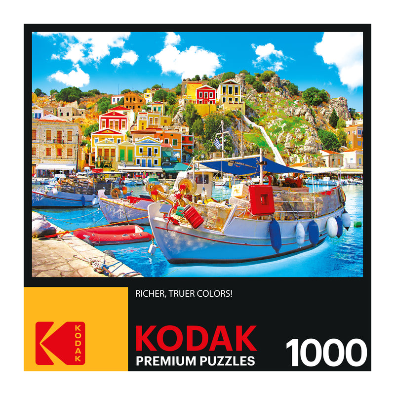 RoseArt - Kodak Premium - Symi with Boats in the Harbor, Greece - 1000 Piece Jigsaw Puzzle featuring a vibrant waterfront scene with colorful buildings, boats, and clear blue water.