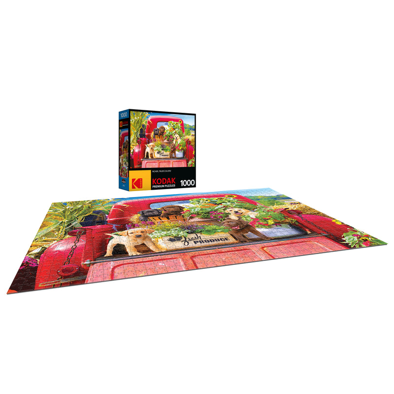 A completed RoseArt - Kodak Premium - Stowaways - 1000 Piece Jigsaw Puzzle featuring a red pickup truck with two puppies in the back, alongside its box with the same image.