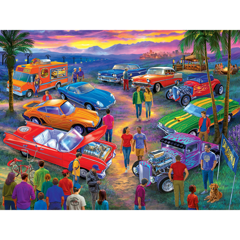 The ROSEART BIGELOW ILLUSTRATIONS - CALIFORNIA CAR SHOW 500 PIECE JIGSAW PUZZLE showcases a vibrant vintage car show scene with diverse people, classic cars, palm trees, and a stunning California sunset.