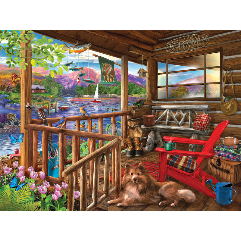 A cozy scene of porch life unfolds with a dog on a cabin porch featuring a red chair, fishing gear, and plants. A "Welcome" sign welcomes sailboats and mountain views. Ideal for jigsaw enthusiasts, captured in the 500-piece ROSEART - BIGELOW ILLUSTRATIONS puzzle.