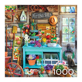 The ROSEART - HOBBY HAVEN - THE POTTING SHED - 1000 PIECE JIGSAW PUZZLE depicts a colorful potting shed with gardening tools, seeds, and flowers on a turquoise workbench. A gray cat rests on the floor as decorative items enhance the wooden wall.