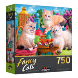 Box of a RoseArt - Fancy Cats - Kitten Tea Party - 750 Piece Jigsaw Puzzle featuring an illustration of three kittens around a tea party table surrounded by vibrant flowers and greenery.