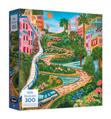 Discover the ROSEART - MILLIE ILLUSTRATES 300 Piece Jigsaw Puzzle featuring Lombard Street, San Francisco. The box showcases vibrant buildings, lush greenery, and a bright sky, capturing the street’s iconic charm.
