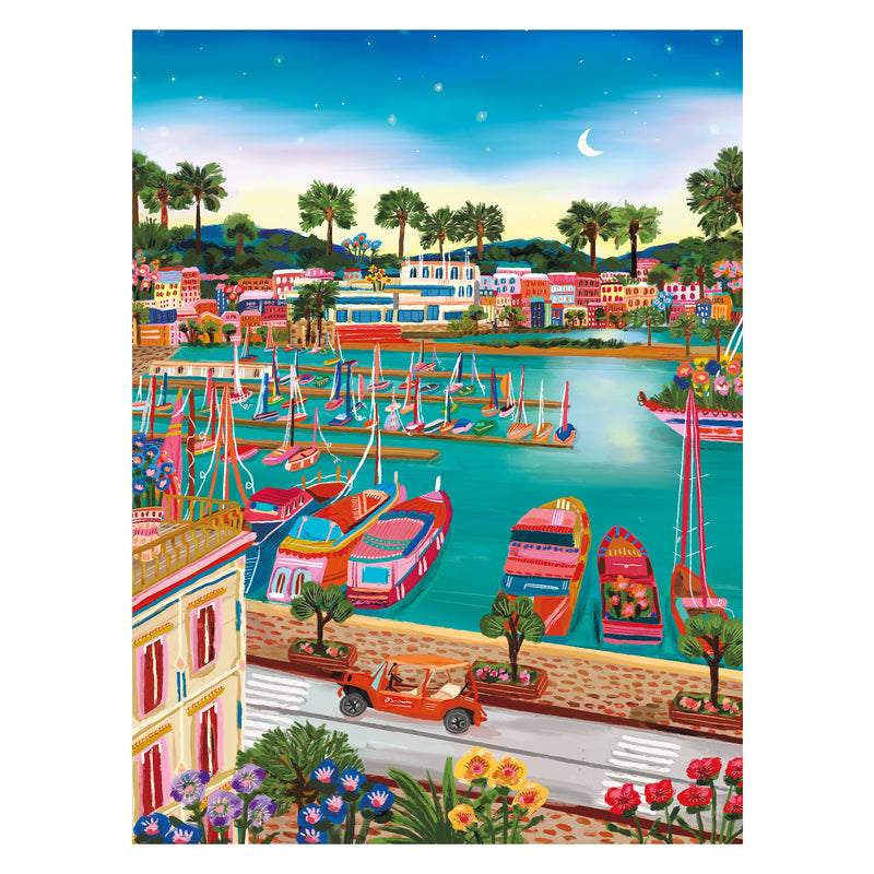 The ROSEART - MILLIE ILLUSTRATES - VIEUX PORT DE CANNES - 300 PIECE JIGSAW PUZZLE features a colorful harbor with sailboats and palm trees, a red vehicle on the road, and a starry sky with a crescent moon.