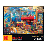 A 2000-piece RoseArt - Kodak Collector - Train Station - 2000 Piece Jigsaw Puzzle featuring a busy train station scene with animals, toys, and colorful details. The box mentions Kodak premium puzzles with richer, truer colors.