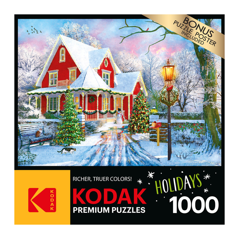 A colorful snowy holiday scene featuring a red house, decorated trees, a streetlamp, snow-covered yard, and a sleigh. The box states "RoseArt - Kodak Premium - Christmas at Home - 1000 Piece Jigsaw Puzzle.