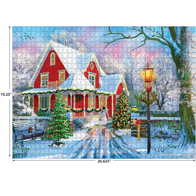 A completed RoseArt - Kodak Premium - Christmas at Home - 1000 Piece Jigsaw Puzzle depicting a snowy winter scene with a red house adorned with Christmas decorations, featuring a lit lamppost, evergreen trees, and a bench. Dimensions are 19.25" by 26.625".