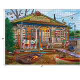 A completed RoseArt - Chris Bigelow - Castaway Bait and Tackle - 1000 Piece Jigsaw Puzzle depicting an old-fashioned bait and tackle shop with fishing supplies, boats, and a canoe in the foreground. The shop has various signs, and a blue sky is in the background.