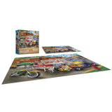 A completed RoseArt - Chris Bigelow - Hot Rod Garage - 1000 Piece Jigsaw Puzzle featuring colorful motorcycles in front of a building is displayed next to its box.