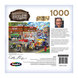 Box for the RoseArt - Chris Bigelow - Hot Rod Garage - 1000 Piece Jigsaw Puzzle featuring a busy hot rod garage scene. Includes a photo and quote from the artist, Chris Bigelow. The image shows various classic cars being worked on in front of a vintage gas station.