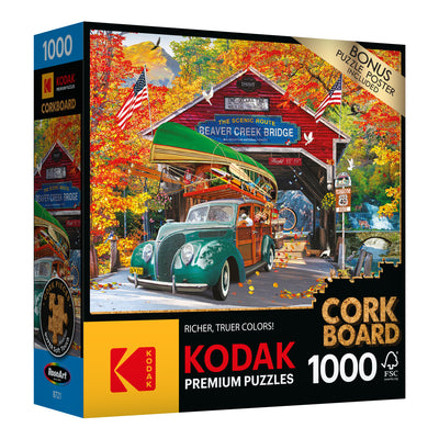 Box of a RoseArt - Kodak Cork - Covered Bridge - 1000 Piece Jigsaw Puzzle featuring an illustration of a vintage car passing through Beaver Creek Bridge, with autumn scenery. Includes a bonus puzzle and an FSC certification.