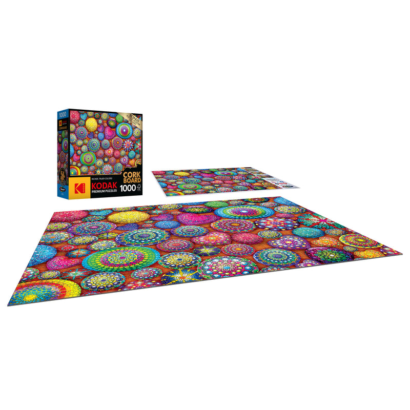 A 1000-piece RoseArt - Kodak Cork - Mandala Stones - 1000 Piece Jigsaw Puzzle featuring a vibrant, colorful mandala pattern is shown completed and disassembled. The puzzle box is on the left.