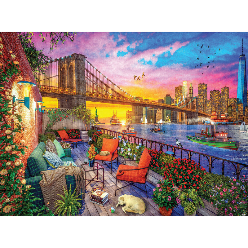 Colorful illustration of a balcony view with the Brooklyn Bridge, boats on the water, vibrant floral decorations, and a city skyline at sunset. A yellow dog naps on the deck amid patio furniture. RoseArt - Kodak Cork - Manhattan Balcony Sunset - 1000 Piece Jigsaw Puzzle.