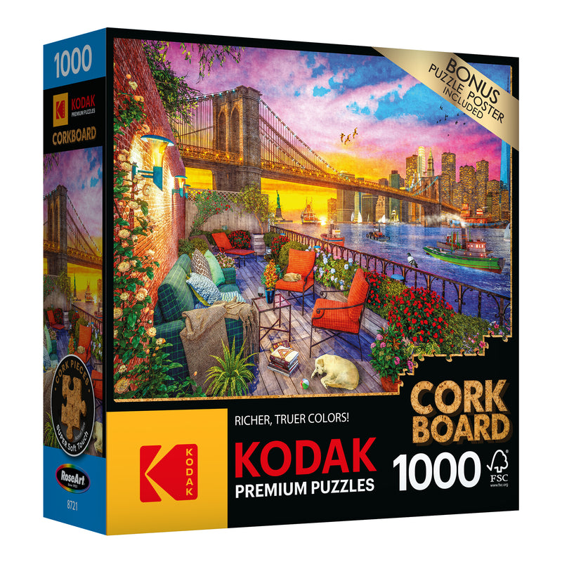 A 1000-piece RoseArt - Kodak Cork - Manhattan Balcony Sunset jigsaw puzzle titled "Manhattan Balcony Sunset" featuring a colorful, detailed scene of a cityscape and bridge at sunset with a bonus puzzle poster included.