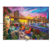 A completed RoseArt - Kodak Cork - Manhattan Balcony Sunset - 1000 Piece Jigsaw Puzzle depicting a sunset view of the Brooklyn Bridge, skyscrapers, and waterfront, with a cozy patio furnished with chairs, flowers, and a small dog. Dimensions: 26-5/8" x 19-1/4".