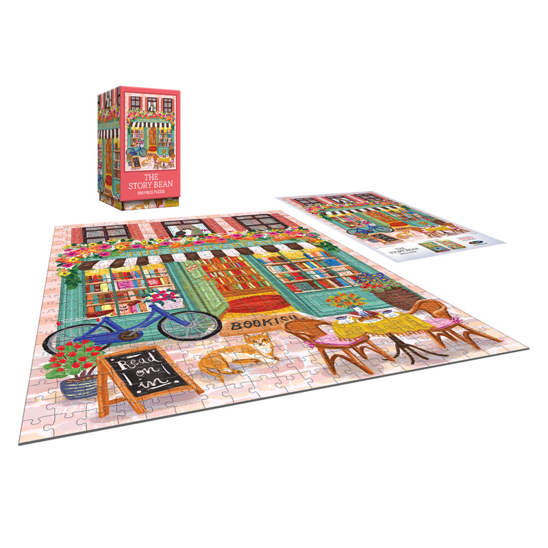 The completed ROSEART VERTICAL VISIONS - The Story Bean 500 piece jigsaw puzzle and its box display a colorful bookstore scene with flowers, a bicycle, and outdoor tables. The puzzle is shown next to the box and reference image.