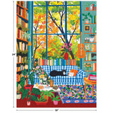 Relax with ROSEART - VERTICAL VISIONS Cozy Reading Room 500 PIECE JIGSAW PUZZLE: a black and white cat lounges on a blue plaid sofa in a plant-filled space, with books, guitar, and autumn trees seen through large windows.