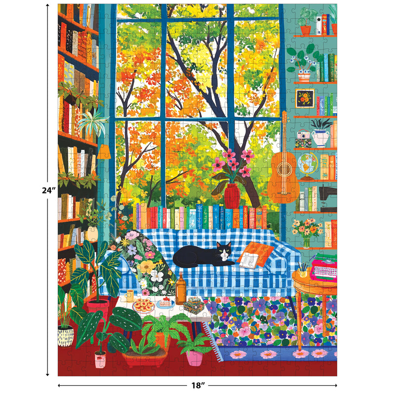 Relax with ROSEART - VERTICAL VISIONS Cozy Reading Room 500 PIECE JIGSAW PUZZLE: a black and white cat lounges on a blue plaid sofa in a plant-filled space, with books, guitar, and autumn trees seen through large windows.
