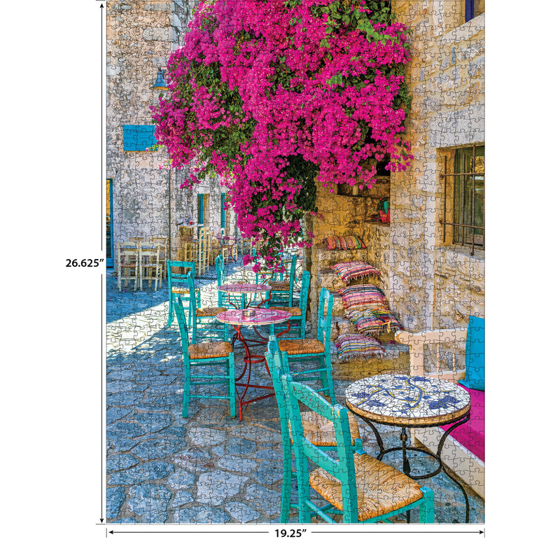 A colorful outdoor cafe with turquoise chairs and tables sits under a large pink bougainvillea on a stone-paved street. Dimensions of the image are marked as 26.625 inches high and 19.25 inches wide. The product is the RoseArt - Kodak Premium - Village Areopoli - 1000 Piece Jigsaw Puzzle.