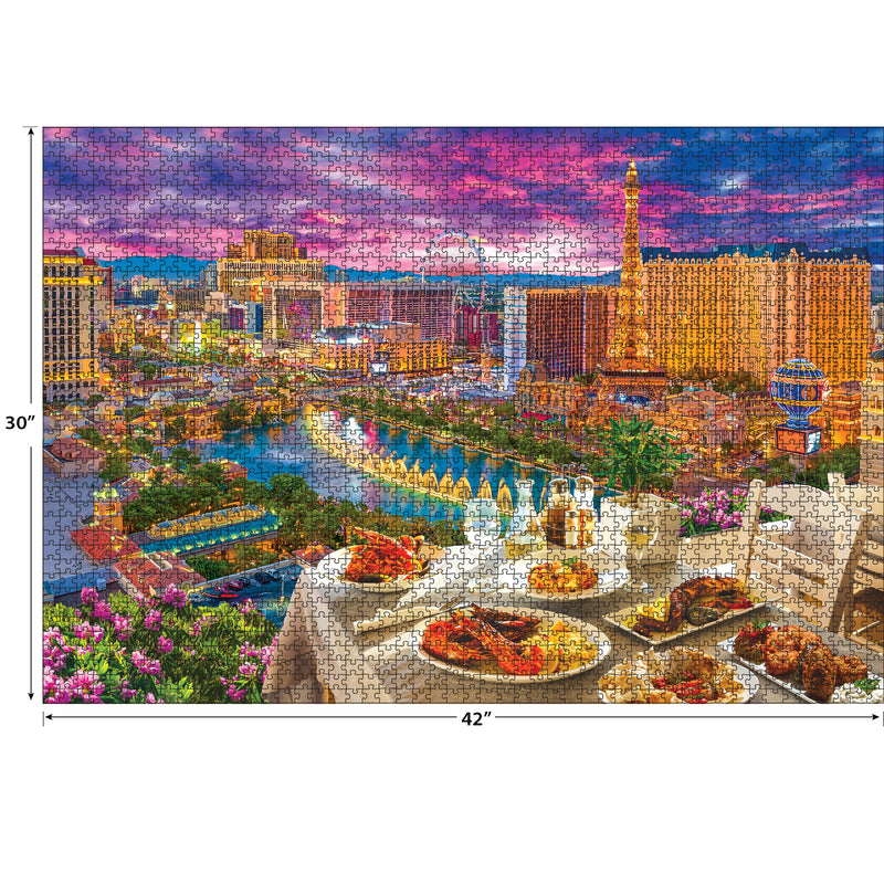 A completed RoseArt - Kodak Premium - La Vida Las Vegas - 3000 Piece Jigsaw Puzzle depicts a vibrant view of a cityscape with tall buildings, fountains, and a rooftop dining setup in the foreground during sunset.