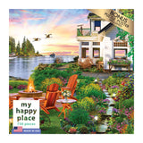 Box cover of a 750-piece puzzle titled "RoseArt - My Happy Place - Harbor House - 750 Piece Jigsaw Puzzle," depicting a colorful garden scene with a lake, Adirondack chairs, and a house at sunset. Bonus puzzle poster included. Made in USA.