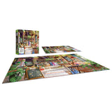 A completed RoseArt - My Happy Place - The Neighborhood Cafe - 750 Piece Jigsaw Puzzle and its box are displayed on a flat surface with another unfinished puzzle. The image on the puzzle shows a colorful indoor scene with plants and various objects.