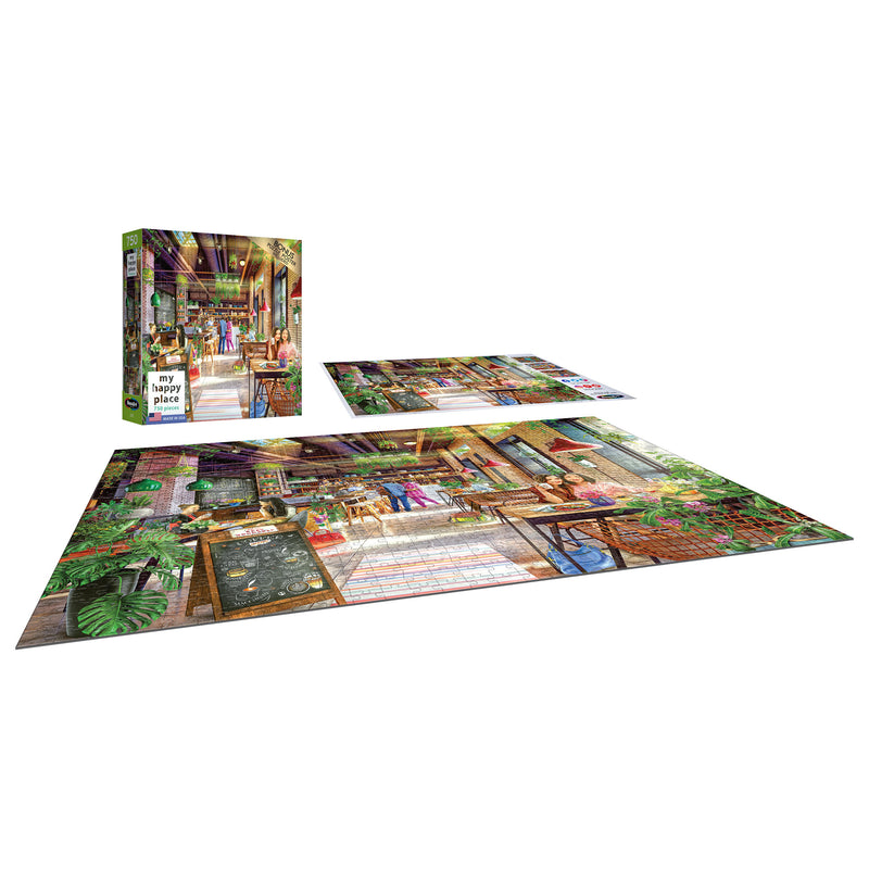 A completed RoseArt - My Happy Place - The Neighborhood Cafe - 750 Piece Jigsaw Puzzle and its box are displayed on a flat surface with another unfinished puzzle. The image on the puzzle shows a colorful indoor scene with plants and various objects.