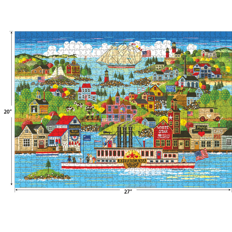 A colorful RoseArt - Home Country - The Americana - 1000 Piece Jigsaw Puzzle depicting a riverboat scene with houses, buildings, and a sailboat in the background. The puzzle measures 27 inches wide and 20 inches tall.