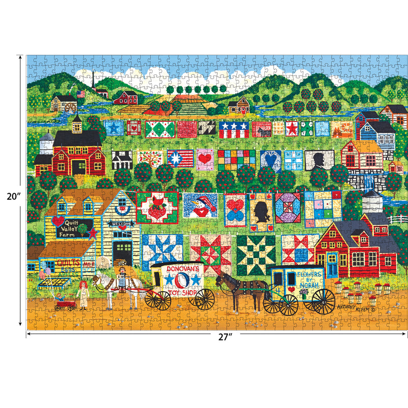 Colorful RoseArt - Home Country - Quilt Valley Farm - 1000 Piece Jigsaw Puzzle depicting a lively farm scene with quilt patterns, various buildings, people, a horse-drawn cart, and rolling green hills in the background. Puzzle dimensions are 20" x 27".