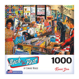 A 1000-piece puzzle titled "RoseArt - Back to the Past - Record Store - 1000 Piece Jigsaw Puzzle" by Edward Wargo. The image depicts a vibrant vintage record store with people browsing vinyl records. Bonus puzzle poster included. Made in USA.