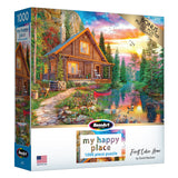 A 1000-piece puzzle box displaying a scenic illustration of a log cabin by a pond surrounded by colorful trees and mountains. The box mentions a bonus poster and the title "RoseArt - My Happy Place - Forest Cabin Home - 1000 Piece Jigsaw Puzzle" by David Maclean.