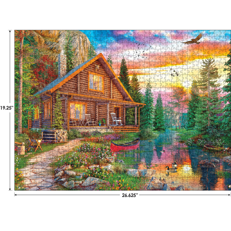 A scenic image of a log cabin by a lake with a canoe, surrounded by trees and colorful flowers. A sunset sky with clouds and a flying bird are in the background. Dimensions: 26.625" x 19.25". Product Name: RoseArt - My Happy Place - Forest Cabin Home - 1000 Piece Jigsaw Puzzle