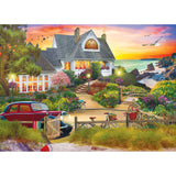 A coastal house with a colorful garden is shown at sunset. Bicycles, a red car, and a path leading to the beach are present, with birds flying in a vibrant sky. This is captured beautifully in the RoseArt - My Happy Place - Seaside Hill - 1000 piece jigsaw puzzle.
