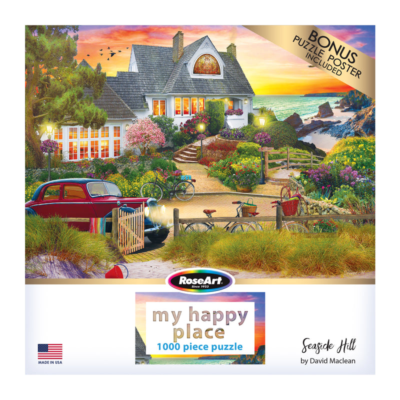 Box cover of a 1000-piece jigsaw puzzle titled "RoseArt - My Happy Place - Seaside Hill - 1000 piece jigsaw puzzle" by David Maclean, depicting a scenic coastal cottage with a vintage car and lush garden, produced by RoseArt.